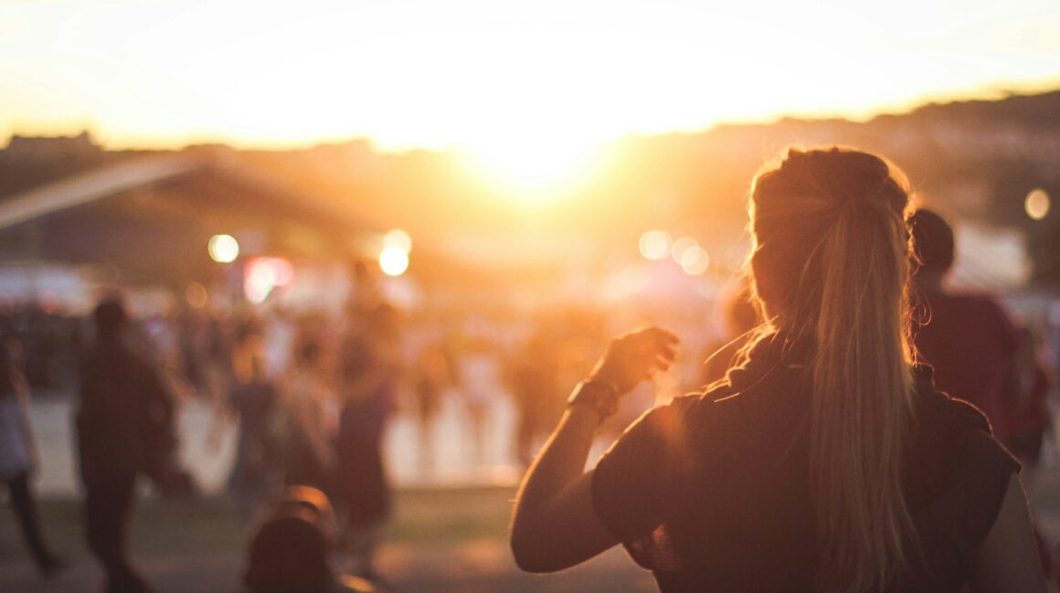 back of woman at festival with others blurred in background